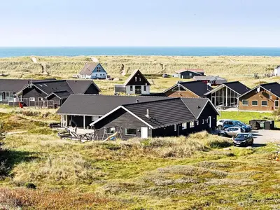 a group of houses on a hill near the ocean at Luxury Pool Retreat by Sea - By Traum Ferienwohnungen in Harboør