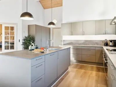 a kitchen with white cabinets and a counter top at Luxury Pool Retreat by Sea - By Traum Ferienwohnungen in Harboør
