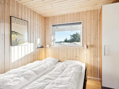 a room with a bed in a wooden wall at Luxury Pool Retreat by Sea - By Traum Ferienwohnungen in Harboør