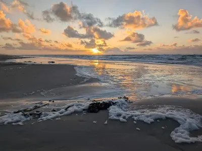 a sunset on the beach with the tide coming in at 6 person holiday home in Blokhus-By Traum in Blokhus