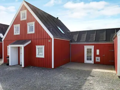 a red barn with a large garage at 6 person holiday home in Blokhus-By Traum in Blokhus