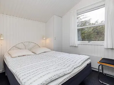 a white bedroom with a bed and a window at Luxury Retreat near Beach - By Traum Ferienwohnungen in Blokhus
