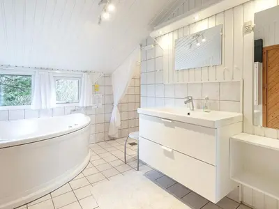 a white bathroom with a tub and a sink at Luxury Retreat near Beach - By Traum Ferienwohnungen in Blokhus