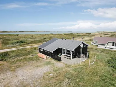 a black house in the middle of a field at 6 person holiday home in Lemvig-By Traum in Trans