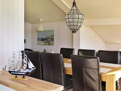 a dining room with a table and chairs and a lamp at 6 person holiday home in Lemvig-By Traum in Trans