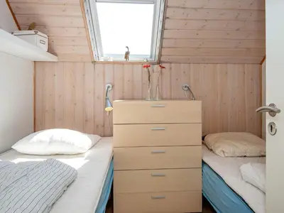 a bedroom with two beds and a dresser and a window at 6 person holiday home in Harboøre-By Traum in Harboør