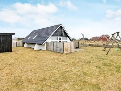 a house with a black roof and a playground at 6 person holiday home in Harboøre-By Traum in Harboør