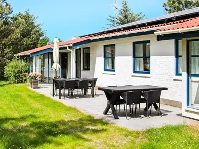 a patio with black tables and chairs in front of a house at 8 person holiday home in Fjerritslev-By Traum in Slettestrand