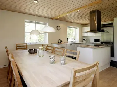 a kitchen and dining room with a large wooden table at 8 person holiday home in Fjerritslev-By Traum in Slettestrand