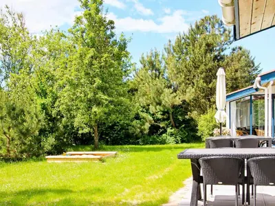 a patio with a table and chairs in a yard at 8 person holiday home in Fjerritslev-By Traum in Slettestrand