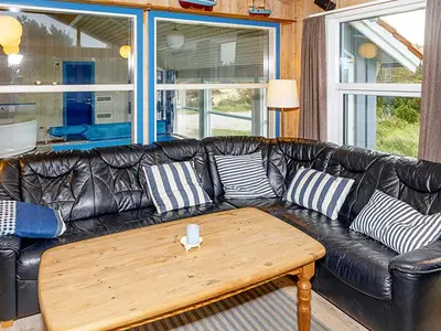 a black leather couch with a wooden coffee table at Luxury Pool House near Beach - By Traum Ferienwohnungen in Klitmøller