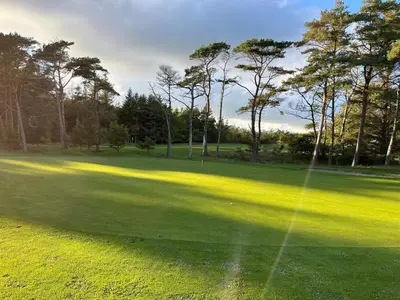 a view of a golf green with trees in the background at Luxury Pool House near Beach - By Traum Ferienwohnungen in Klitmøller
