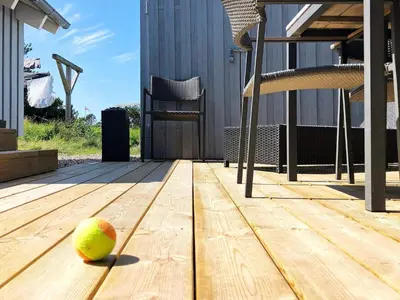 an apple sitting on a wooden floor on a deck at Luxury Pool House near Beach - By Traum Ferienwohnungen in Klitmøller