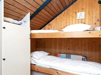 a bedroom with two bunk beds in a wooden cabin at Seaside Rustic Retreat - By Traum Ferienwohnungen in Flovtrup