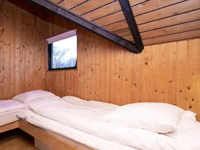 a bed in a wooden room with a window at Seaside Rustic Retreat - By Traum Ferienwohnungen in Flovtrup
