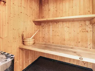 a wooden sauna with a wooden shelf and a bucket at 17 person holiday home in Roslev-By Traum in Vester Grønning