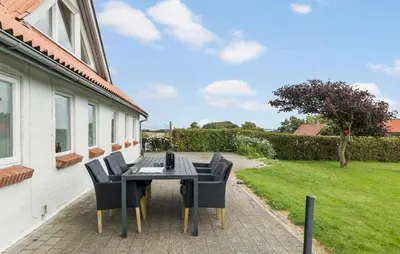 a patio with a table and chairs in a yard at Cozy Home In Øster Assels With Wifi in Øster Assels
