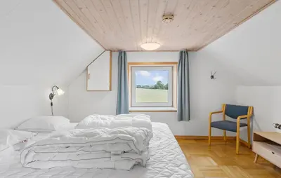 a bedroom with a bed and a window and a chair at Cozy Home In Øster Assels With Wifi in Øster Assels