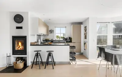 a kitchen and living room with a fireplace and a table at Beautiful Home In Thisted With Sauna in Thisted