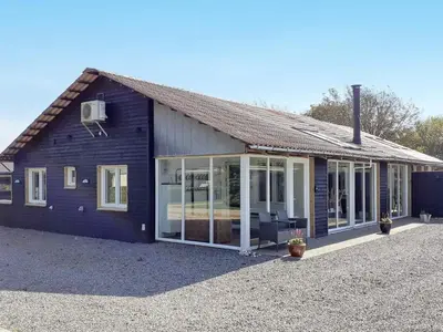 a house with large sliding glass doors on it at 12 person holiday home in Vinderup-By Traum in Vinderup