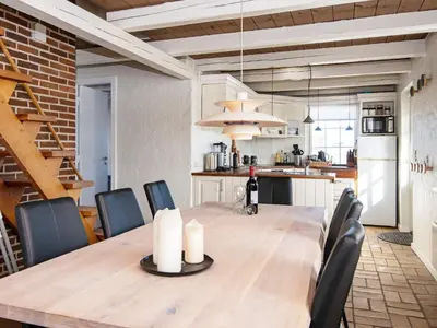 a dining room with a wooden table and chairs at 9 person holiday home in Harboøre-By Traum in Harboør