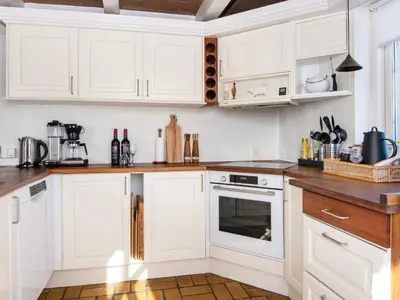 a kitchen with white cabinets and wooden counter tops at 9 person holiday home in Harboøre-By Traum in Harboør