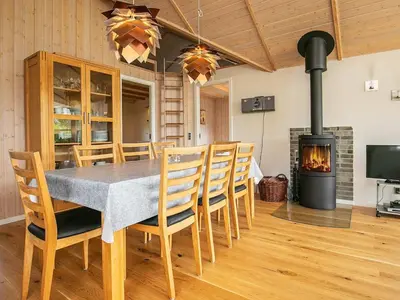 a dining room with a table and chairs and a fireplace at 8 person holiday home in Lemvig-By Traum in Lemvig
