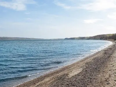a beach with a rocky shore and the ocean at 8 person holiday home in Lemvig-By Traum in Lemvig