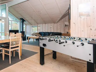 a ping pong table in a living room with a table and a tableablish at 8 person holiday home in Harboøre-By Traum in Harboør