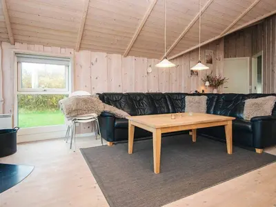 a living room with a black leather couch and a table at 8 person holiday home in Harboøre-By Traum in Harboør