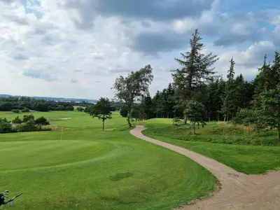 a dirt road leading to a golf green at 8 person holiday home in Skals in Hjarbæk