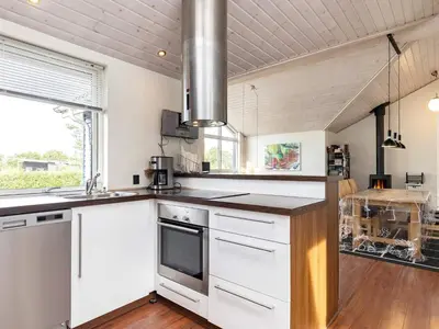 a kitchen with white cabinets and a counter top at 8 person holiday home in Skals in Hjarbæk