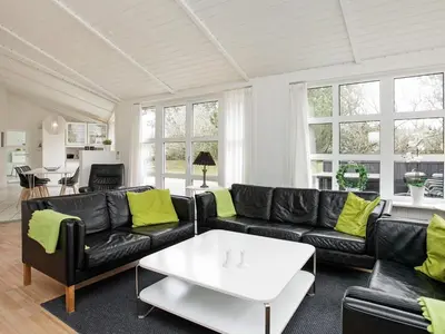 a living room with a black couch and a table at Luxury Retreat with Pool - By Traum Ferienwohnungen in Grønhøj