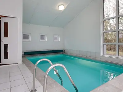 a swimming pool with blue water in a room at Luxury Retreat with Pool - By Traum Ferienwohnungen in Grønhøj