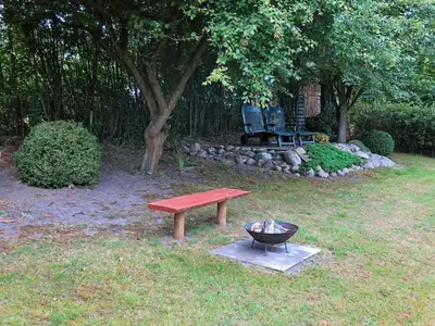 a picnic table and a grill and a bench in a yard at 6 person holiday home in Struer-By Traum in Remmer Strand
