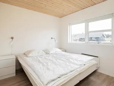 a white bedroom with a bed and a window at 8 person holiday home in Brovst-By Traum in Brovst