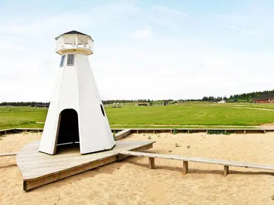a lighthouse sitting on top of a sandy beach at 8 person holiday home in Brovst-By Traum in Brovst