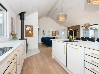an open kitchen and living room with white cabinets at Luxury Retreat by the Sea - By Traum Ferienwohnungen in Harboør