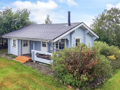 a small blue house with a porch in a yard at 6 person holiday home in Roslev-By Traum in Flovtrup