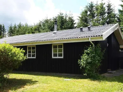 a black house with a gambrel roof at 6 person holiday home in Blokhus-By Traum in Blokhus
