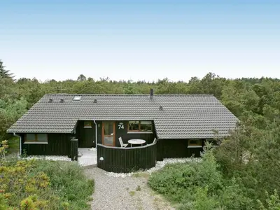 a small black house with a table in front of it at Cozy Beach House with Spa - By Traum Ferienwohnungen in Torup Strand