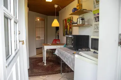 a kitchen with a counter and a table with a microwave at Astrup vig Spa og Sauna in Roslev