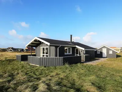 a black and white house sitting on top of a field at Seaside Fun & Relaxation-By Traum in Harboør