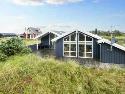 a black house with white windows and a red house at 10 person holiday home in Harboøre-By Traum in Harboør
