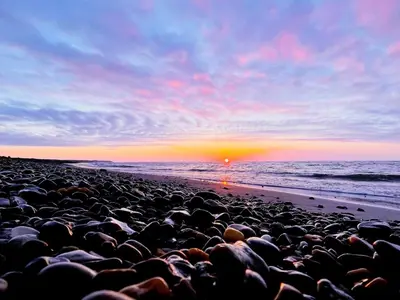a group of rocks on a beach at sunset at Secluded Haven in Thorup - By Traum Ferienwohnungen in Torup Strand