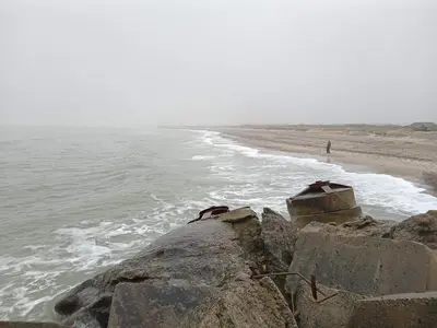 a person walking on the beach next to the ocean at Secluded Haven in Thorup - By Traum Ferienwohnungen in Torup Strand