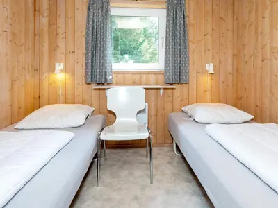 two beds in a room with wooden walls and a window at Secluded Haven in Thorup - By Traum Ferienwohnungen in Torup Strand