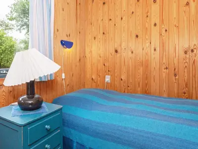 a bedroom with a bed and a lamp on a dresser at 5 person holiday home in Højslev-By Traum in Bøstrup