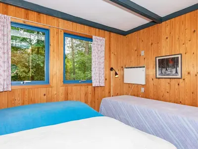 two beds in a room with wooden walls and windows at 5 person holiday home in Højslev-By Traum in Bøstrup