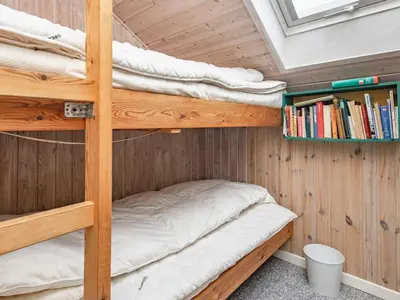 a bunk bed room with two bunk beds and a book shelf at 6 person holiday home in Roslev-By Traum in Vester Grønning